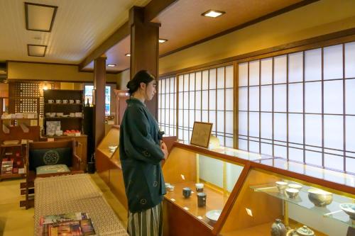 a woman standing in a room with a counter at 岩井温泉　岩井屋 in Iwamicho