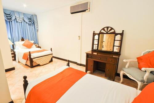 a bedroom with a bed and a mirror and a chair at Paradise Garden Hotel and Convention Center Boracay Powered by ASTON in Boracay
