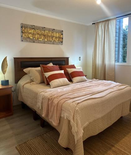 a bedroom with a large bed with pillows at Desconexión y Paz in Pucón