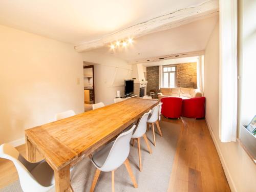 a dining room with a wooden table and white chairs at Historic Watermill in Bohan in Vresse-sur-Semois