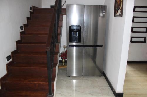 a refrigerator sitting next to a staircase in a house at Holiday Home Asgiri Walpola Gampaha in Gampaha