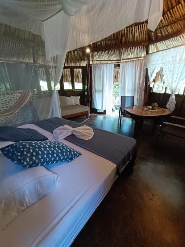 a bedroom with two beds and a table at El Paraiso de Carmen in Palomino