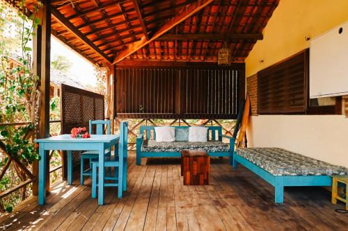 a room with two beds and a table on a deck at Casa Bem Te Vi in Amontada