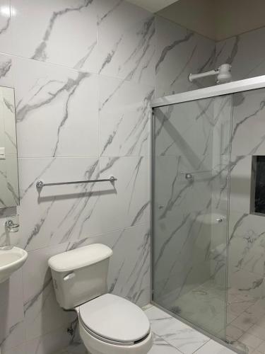 a bathroom with a toilet and a glass shower at Suites 115 in Culiacán