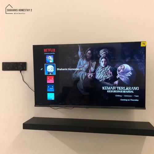 a flat screen tv hanging on a wall at Shahanis Homestay II , Spacious Home in Kemaman in Cukai