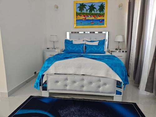 a bedroom with a bed with blue pillows at Residencial Las Estrellas in Boca Chica