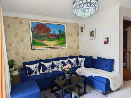 a blue couch in a living room with a painting at Residencial Las Estrellas in Boca Chica