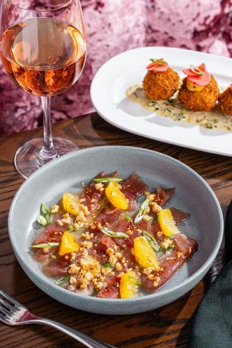 a table with a bowl of food and a glass of wine at Grand Bohemian Mountain Brook, Autograph Collection in Birmingham