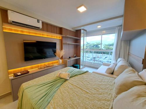 a bedroom with a large bed and a flat screen tv at Nixxus Luxo e requinte á 50 m do mar e próximo as piscinas Naturais in Porto De Galinhas