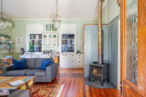 a living room with a couch and a stove at Old School House in Queenstown