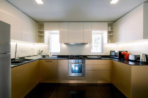 a kitchen with white cabinets and a stove top oven at Luxurious Residence Rawai in Phuket Town