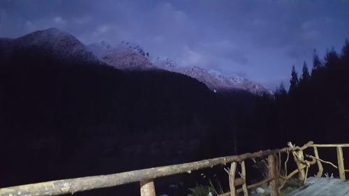 a view of a mountain range with a wooden fence at Cabaña Ugarit Chabranco Maihue Futrono in Futrono