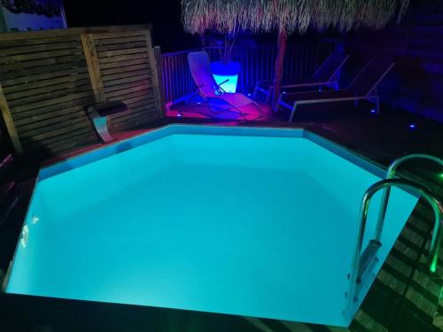 una piscina con illuminazione blu in un cortile posteriore di Villa Kasanaco avec vue sur la mer a Case-Pilote