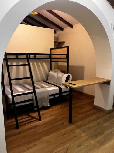 a bedroom with a bunk bed and a desk at Magiko Suites in Roldanillo