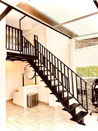a black staircase in a room with a table and chairs at La Vista EcoHouse in Macanal