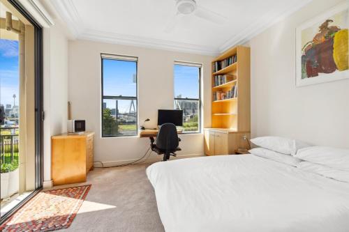 a bedroom with a bed and a desk with a computer at Elegant Stay in Balmain with Pool Access in Sydney