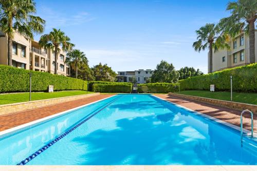 a swimming pool with blue water in front of a building at Elegant Stay in Balmain with Pool Access in Sydney