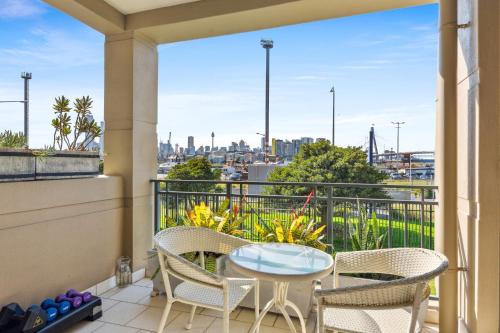 a balcony with a table and chairs and a view of the city at Elegant Stay in Balmain with Pool Access in Sydney