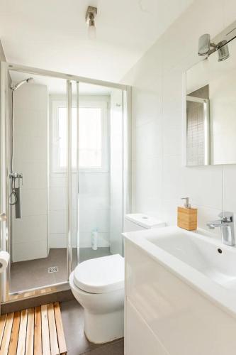 a white bathroom with a toilet and a sink at 10m Casco Viejo in Bilbao