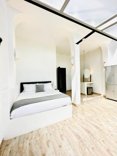 a bedroom with white walls and a white bed at La Vista EcoHouse in Macanal