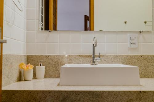a white sink in a bathroom with a mirror at Recanto Alter do Chão in Alter do Chao