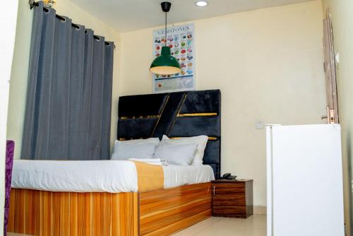 a bed with a wooden headboard in a room at Ontario Suites in Lagos