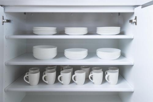 a shelf filled with white plates and cups at THE Sakura in Kami-furano
