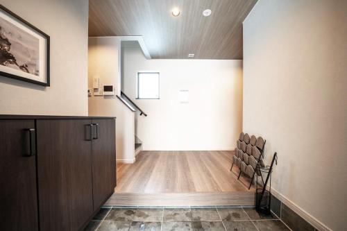 an empty room with a staircase in a house at THE Sakura in Kami-furano