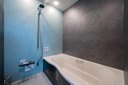 a bathroom with a tub and a shower at THE Sakura in Kami-furano