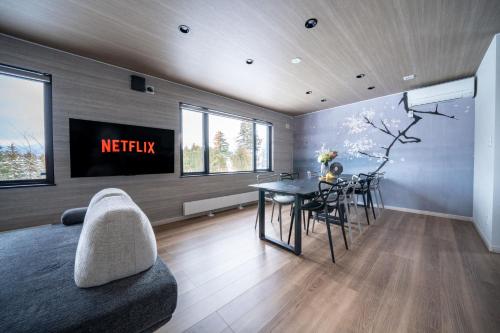 a living room with a television and a dining table at THE Sakura in Kami-furano