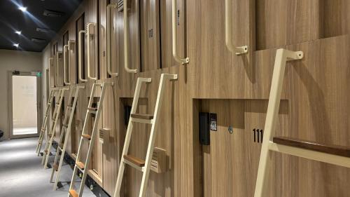 a row of lockers in a room with ladderbacks at Dosare Capsule Hotel in Sentool