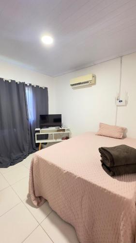 a bedroom with a bed with a pink blanket at Canto do Mangue in Cascavel