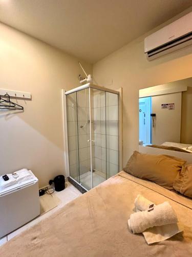 a room with a bed and a glass shower at Cine Rio Hostel RJ in Rio de Janeiro