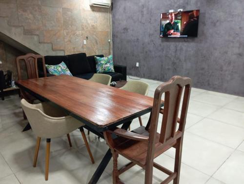 a wooden table and chairs in a living room at La Frontera in Puerto Iguazú