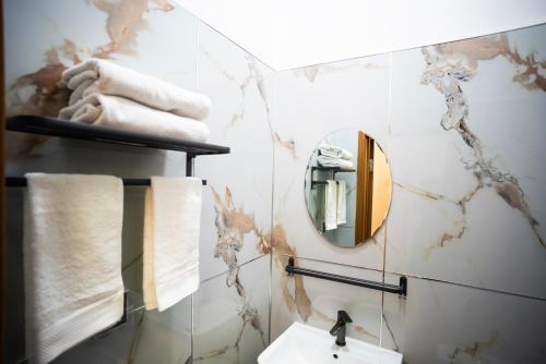 a bathroom with a mirror and towels on a wall at Tsolmon's Serviced Apartments in Ulaanbaatar
