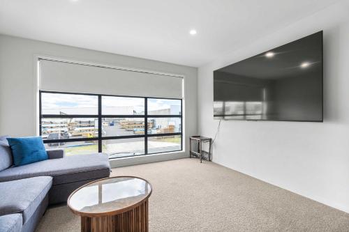 a living room with a couch and a table at Coastal Bliss in Mount Maunganui