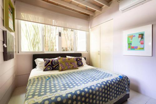 a bedroom with a bed in a room with a window at Nest Bungalow - Pool Walking To The Beach in Santa Teresa Beach
