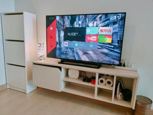 a flat screen tv sitting on a white entertainment center at The Kith Plus - Wifi Swimming Pool Gym BTS Samrong in Ban Khlong Samrong
