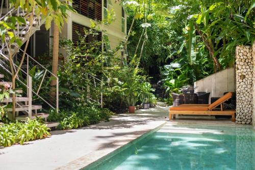 a swimming pool with a bench next to a house at Bungalow in Santa Teresa Beach