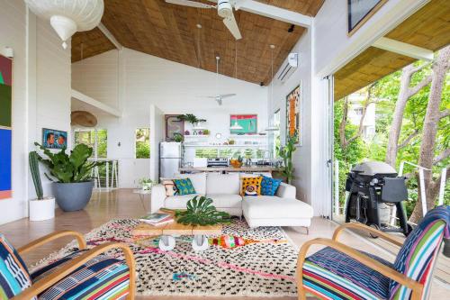 Una sala de estar con un sofá blanco y sillas. en Casazul - Tropical Escape Ocean Views, en Santa Teresa Beach