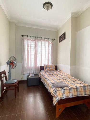 a bedroom with a bed and a window at Combretrata in Phnom Penh