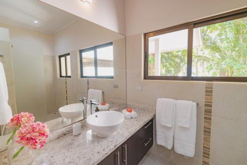 Un baño con dos lavabos y un espejo grande. en Luxury Beachfront Villabest Surf Spot, en Santa Teresa Beach