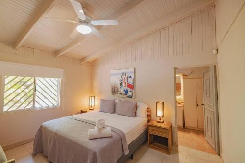 Un dormitorio con una cama y un ventilador de techo. en Luxury Beachfront Villabest Surf Spot, en Santa Teresa Beach