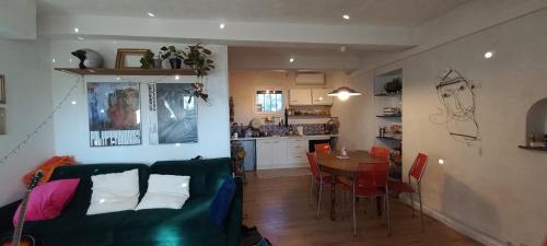 un salon et une cuisine avec un canapé et une table dans l'établissement Gite la Muscadelle l Isle sur sorgue, à LʼIsle-sur-la-Sorgue