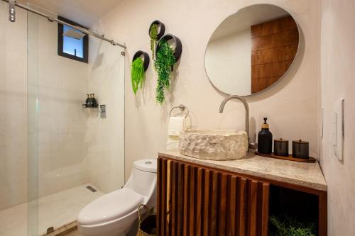 a bathroom with a toilet and a mirror at MarinaWellmina-Sunset Pool Vibes in La Paz