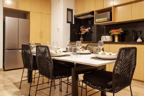 a kitchen with a table and chairs with wine glasses at MarinaWellmina-Sunset Pool Vibes in La Paz