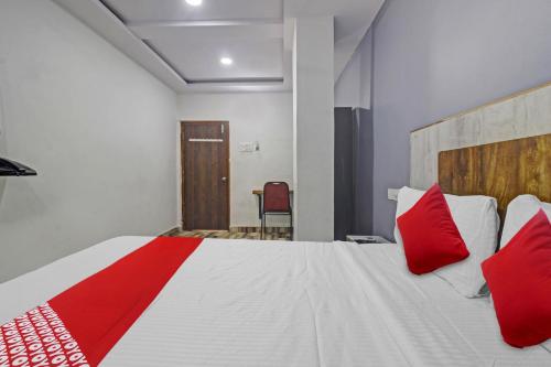 a bedroom with a large bed with red pillows at Hotel O Sri Sai Regency in Hyderabad