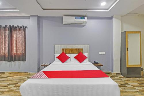 a bedroom with a large bed with red pillows at Hotel O Sri Sai Regency in Hyderabad