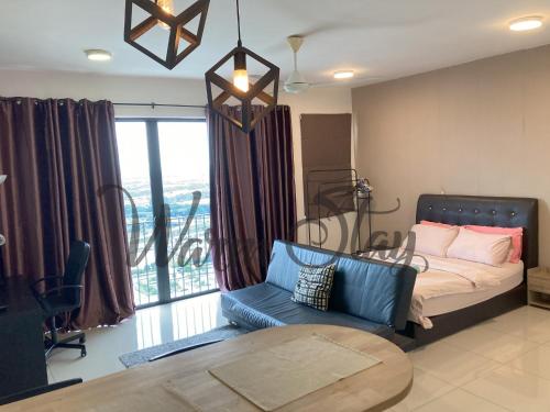 a bedroom with a bed and a couch and a table at Warm Stay at Trefoil in Setia Alam