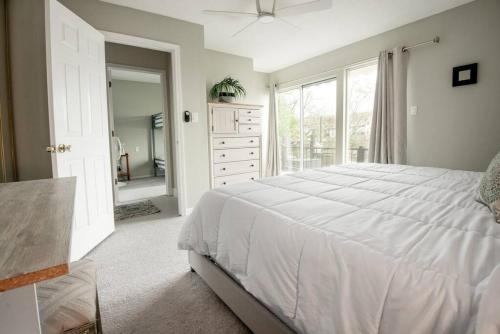 a bedroom with a white bed and a large window at Serene Duplex Lakefront Retreat: sleeps up to 20 in Rocky Mount